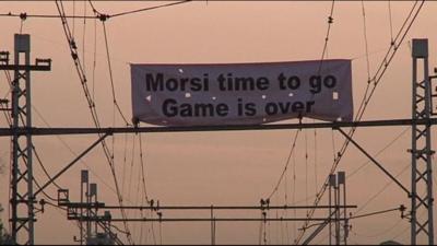 Sign reading "Morsi time to go, game is over"