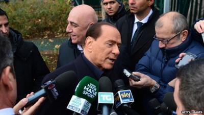 Silvio Berlusconi surrounded by reporters