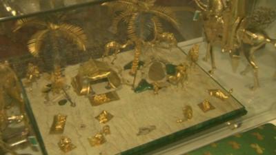 A desert scene made from gold on display