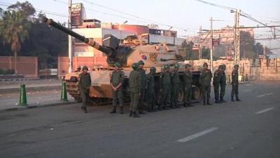 Soldiers standing next to a tank