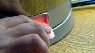 Woman switching an electric kettle on