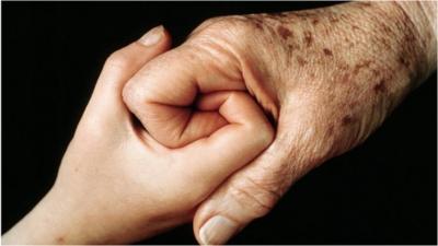 Old and young person holding hands