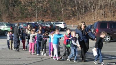 Police personnel lead children from the Sandy Hook Elementary School