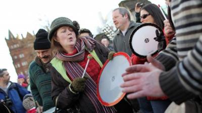 Demonstrators play percussion instruments as up to 1,000 people gather to take part in a peace rally outside Belfast City Hall in Belfast