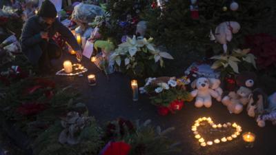 Woman lights candles at vigil for victims of shooting in Newtown, Connecticut