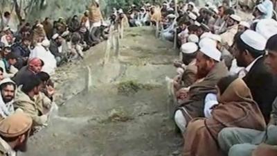 Mourners sitting around graves