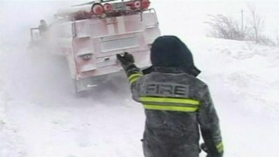 Emergency services helping a vehicle trapped in the snow