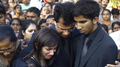 Benedict Barboza, centre, holds his son Junal, on his right, and daughter Lisha