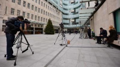 News crews gather outside BBC Broadcasting House in London