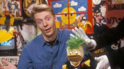 Andy Crane in the broom cupboard with Edd the Duck in 1990