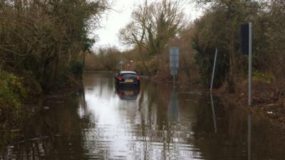 A stranded car in Pingewood where Berkshire Fire and Rescue are working to pump water away from an electricity distribution centre