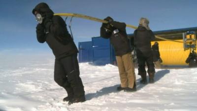 Scientists carrying equipment in Antarctica