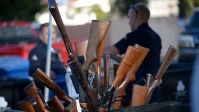 LAPD officers collect guns during the LAPD Gun Buyback Program event in Van Nuys area, north Los Angeles