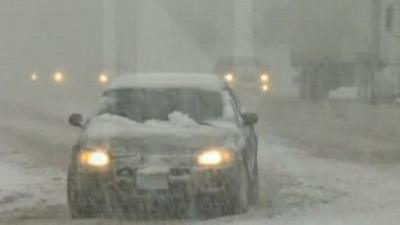 Car with lights in heavy snowfall