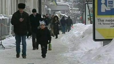 People walk on snow covered street in Ukraine
