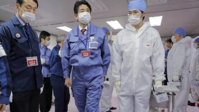 Japan's Prime Minister Shizo Abe with workers at the Fukushima Dai-ichi nuclear power plant (29 Dec 2012)