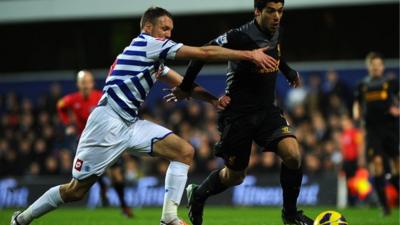 Liverpool's Luis Suarez (r) glides past QPR's Clint Hill