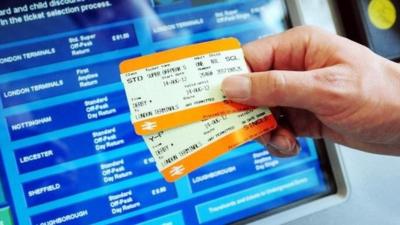 Rail tickets held out in front of ticket machine