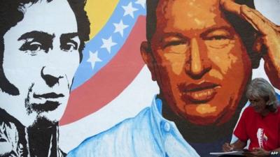 An artist draws next to a painting of Venezuelan President Hugo Chavez in Caracas, on 3 January 2013