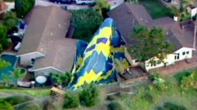 the balloon draped over a tree and a house