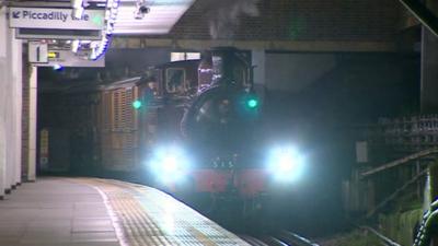 A steam engine pulling into a modern day tube station