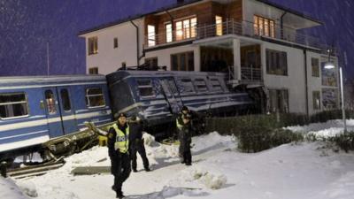 Police guard the scene where a train hit a house in a Stockholm suburb, 15 January