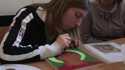 An inmate painting a religious painting