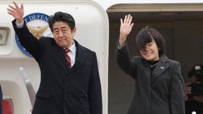 Japanese Prime Minister Shinzo Abe and his wife Akie, wave as they leave Tokyo International Airport on January 16, 2013, en route to Hanoi