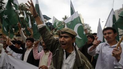 Supporters of Pakistan"s Islamist party Pasban hold national flags