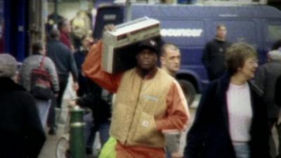 Man carrying a portable cassette player on his shoulder