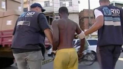 Brazilian officers taking in suspected drug user