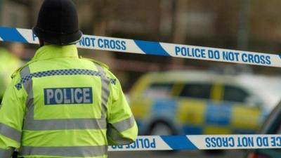 Police officer passing a police cordon