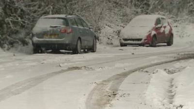 Snow covered cars on road