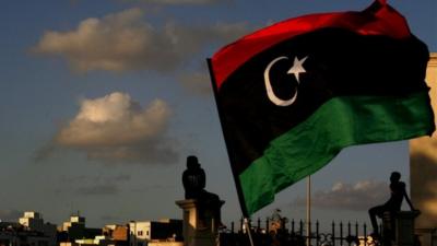 Libyan flag over Benghazi skyline