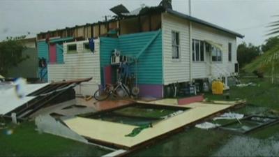 House with walls ripped away by tornado