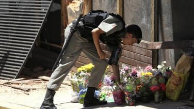 Policeman laying flowers outside club in Brazil