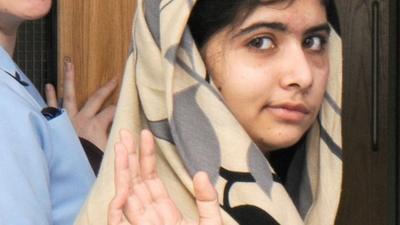 Malala Yousafzai waving as she is discharged from the Queen Elizabeth Hospital in Birmingham