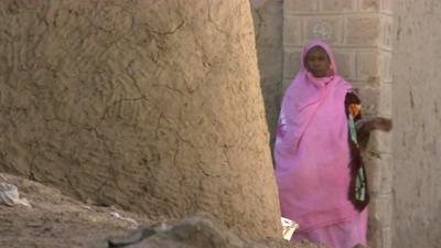 Woman in bright pink scarf and dress