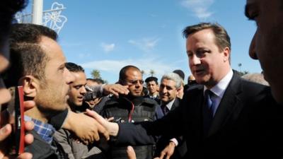 UK Prime Minister David Cameron meeting Libyans, flanked by security guards