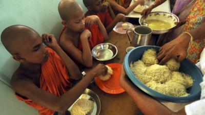 Young monks receive breakfast offerings