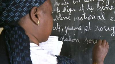 Teacher writing on blackboard