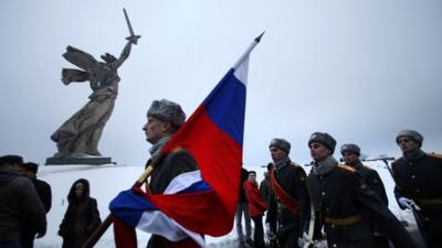 Russian soldiers march by the monument to Motherland