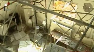 Still image from Syria state TV footage showing damage to room