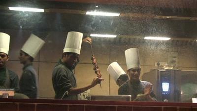 Men preparing a meat dish in a restaurant in Mumbai