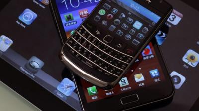 A Blackberry Bold smartphone, a Samsung Galaxy Note phablet, and an Apple iPad 2