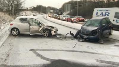 Cars with smashed fronts on icy road, with tailbacks on other carriageway