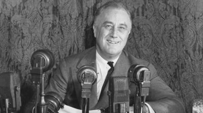 Franklin D Roosevelt sitting with microphones