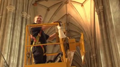 Man on cherry picker in cathedral