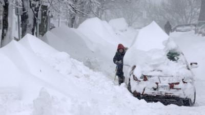 Woman shovels snow