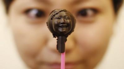 Woman holding a chocolate sculpture of her face